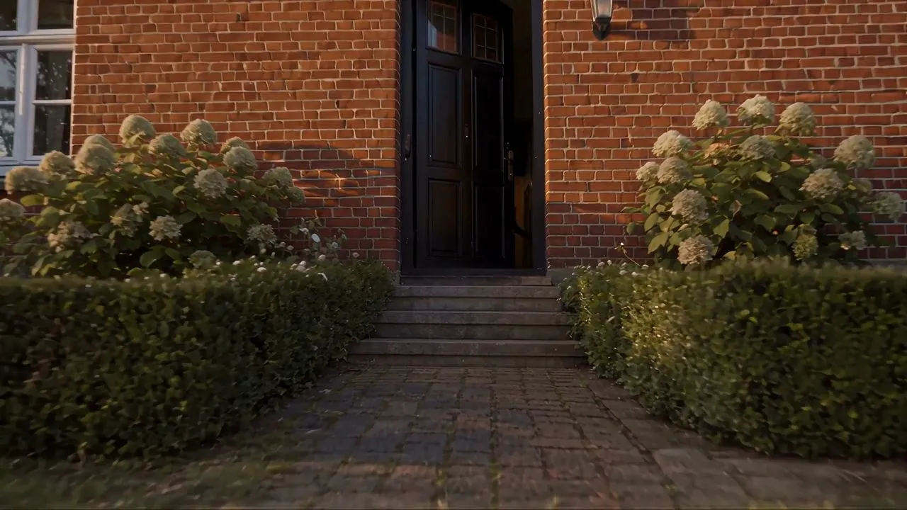 KI-generiertes Bild eines Hauseingangs mit Hortensien, geschnittener Hecke und Backsteinfassade neben einem gepflasterten Weg